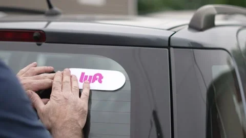 Placing a LYFT Sticker on the Car Before Going To Work Stock Footage 156298905