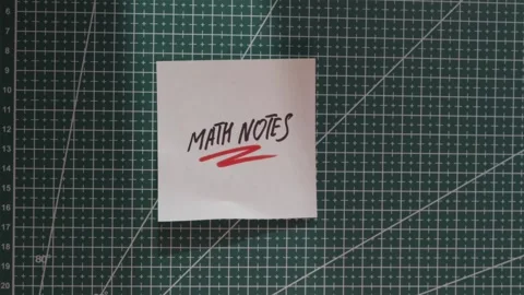 Placing Math Notes paper slip on green cutting mat flat lay Stock Footage 341269396