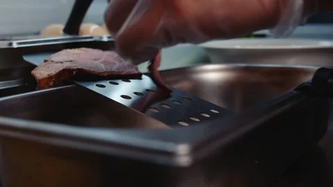 Placing Meat Slices onto a Flat Top Grill Stock Footage 340189811