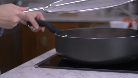 Placing Mesh Splatter Guard On Hot Pan Stock Footage 98600970