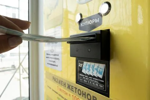 Placing money in a machine with a token receiver Stock Photos