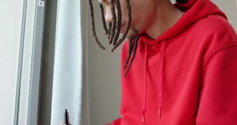 On placing notebook on lap man is writing notes with black pen for study near Stock Footage 345035493