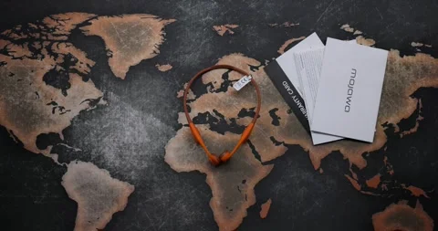 Placing orange open ear headphones on a flat surface along with instructions Stock Footage 297734650