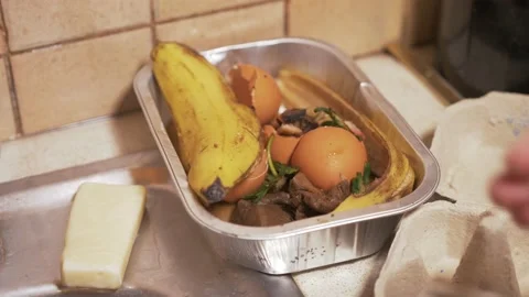 Placing organic fruit scraps into container for composting Stock Footage 227635814