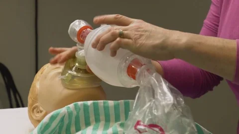 Placing oxygen pump mask on doll patient in simulated exercise Stock Footage 85180602