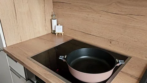 Placing Pan on Hot Electric Stove Top. Girl putting a frying pan on a preheated Stock Footage 305750737
