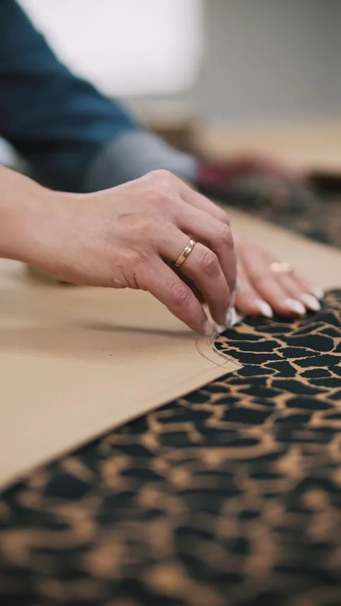 Placing paper pattern on leopard fabric Stock Footage 308723874