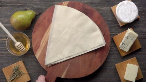 Placing phyllo dough board on table with pie ingredients top view Stock Footage 327459214