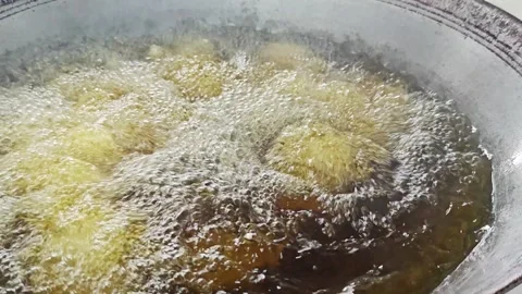 Placing a piece of battered fish into a frying pan with bubbling oil. Stock Footage 342687007