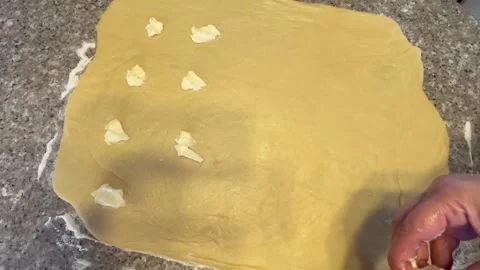 Placing Pieces of Butter on Rolled Dough for Baking Stock Footage 345522393