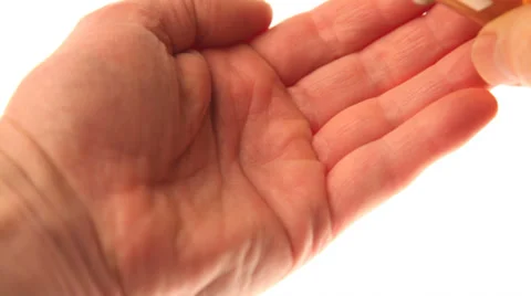 Placing pills in a hand Video stock 32243382