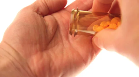 Placing pills in a hand Video stock 32243400