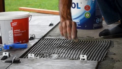 Placing plastic clips for leveling tiles before new tile Stock Footage 255386436