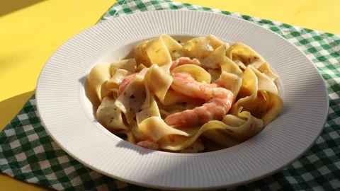 Placing a plate of pasta with shrimp on the table. close-up of a white plate Stock Footage 304682973