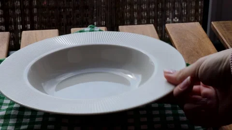 Placing a plate on the table. White ceramic dish on an outdoor wooden surface Stock Footage 304326126