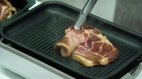 Placing Pork Ribs on Hot Pan with Tongs 動画素材 334828415