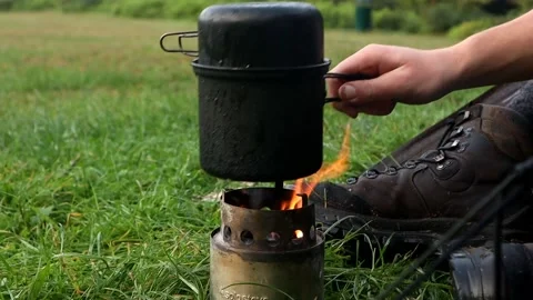 Placing pot on twig stove Stock Footage 154768140