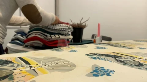 Placing the pressed clothes on the stack of stacked clothes. Stock Footage 119382385