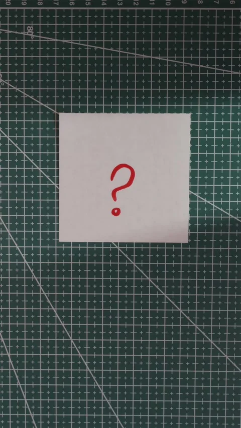 Placing question mark paper note on green cutting mat Stock Footage 341246123