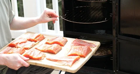Placing raw salmon fish fillets in cooking smoker Stock Footage 88640479