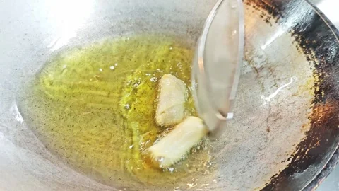 Placing raw spring rolls into hot frying oil inside a wok. Stock Footage 342394654