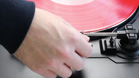 Placing red vinyl record on a turntable. Spinning red LP on a turntable Stock Footage 146283617
