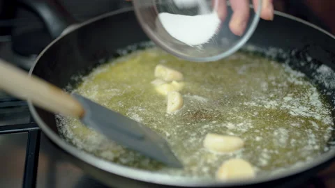 Placing salt in a hot pan while melting butter with a spatula. Stock Footage 132821872