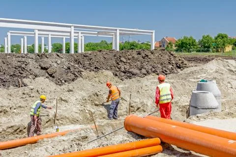 Placing set of new plastic pipes into the ground Stock Photos