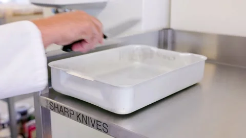 Placing a sharp knife in a used knife tray professional kitchen Stock Footage 231770238