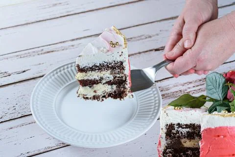 Placing a slice of chocolate cake covered with Swiss meringue buttercream on Stock Photos