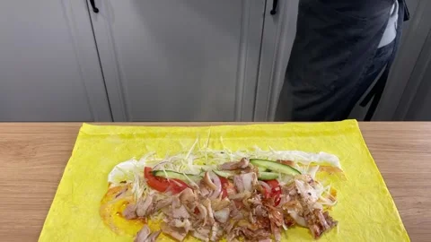 Placing sliced meat on shawarma with vegetables on flatbread Stock Footage 318912197