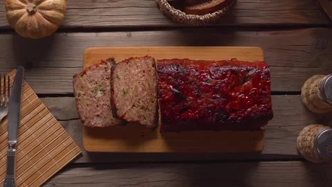 Placing Sliced Meatloaf Board on Rustic Table Top View Video stock 327457948