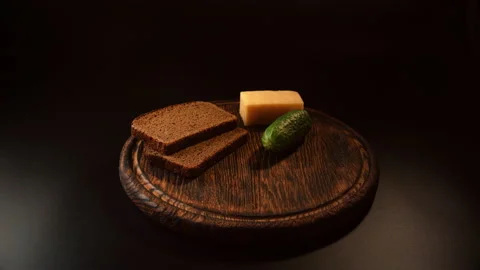 Placing slices of bread, cucumber, cheese on a wooden tray Stock Footage 148625093