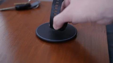 Placing Smart Watch on Wireless Charger in Living Room Vídeo Stock 103046033