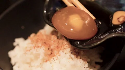 Placing Soy Sauce Marinated Egg Yolk on Rice with Chopsticks Stock Footage 345779052