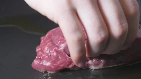 Placing Steak in Pan to Cook Stock Footage 169612444