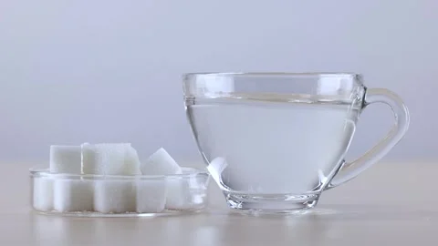 Placing Sugar Cubes and Glass Cup of Water on Table Stock Footage 342488309