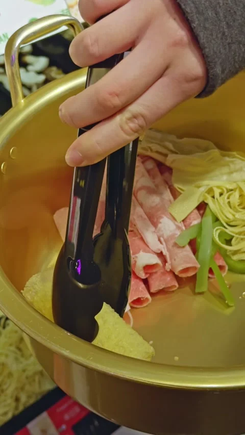 Placing Tofu Roll into Hot Pot Bowl with Tongs Stock Footage 314374691