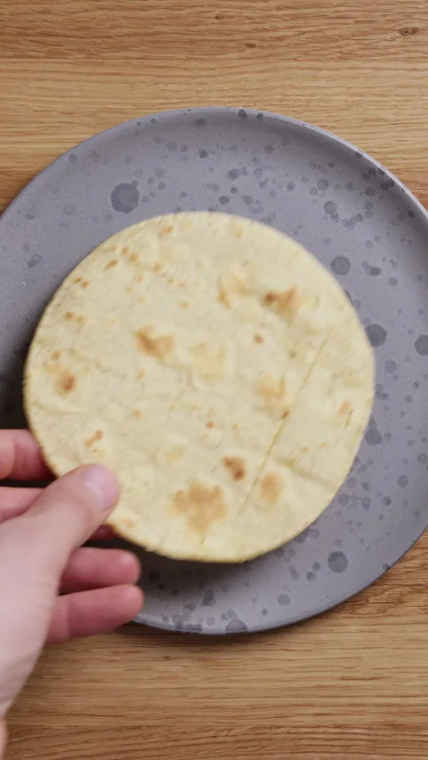 Placing Tortilla on Plate Vertical Top View Видео 336578110