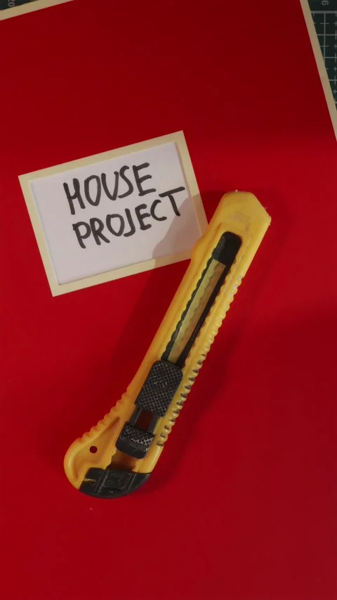 Placing utility knife on House Project red folder flat lay Stock Footage 341246143