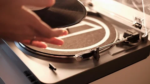 Placing vinyl record on the turntable and playing song Stock Footage 101339758
