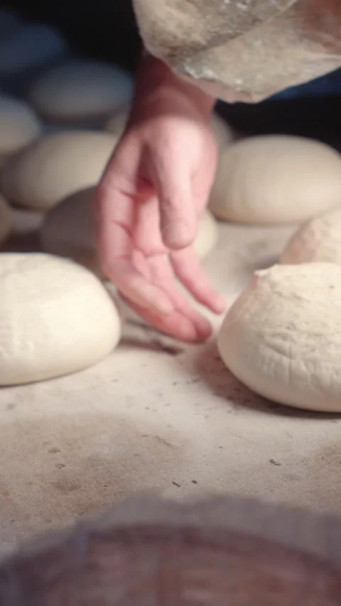 Placing white bread dough pieces on a baking board in a bakery Stock Footage 344313369
