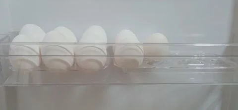 Placing white eggs into the refrigerator door shelf. Stock Footage 334616874