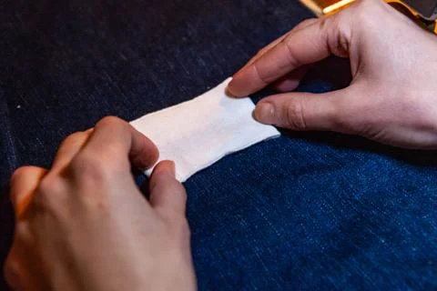 Placing white patch on blue jean fabric 스톡 사진