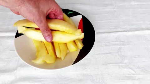 Placing Yellow Melon Slices on a Bold Ceramic Plate Stock Footage 317073354
