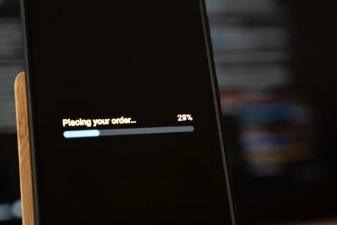 Placing your order progress bar at 28 percent on a dark smartphone screen beside Stock Photos
