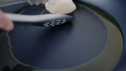 Placing/adding multiple scallops into a preheated pan with oil in 4K. Stock Footage 138058273