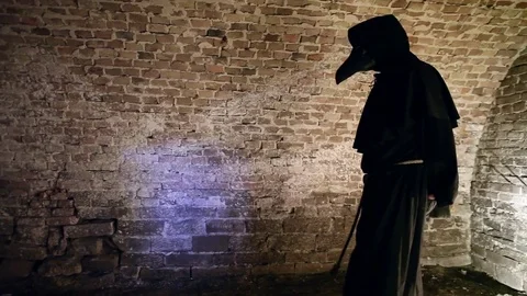 Plague doctor patient throws bread Stock Footage