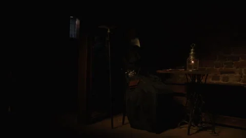 Plague Doctor using a lantern while reading something in the dark Video stock 258427241