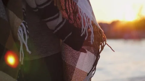 Plaid plaid on the background of the sunset on the beach. girl wrapped in a Stock-Footage 141483187